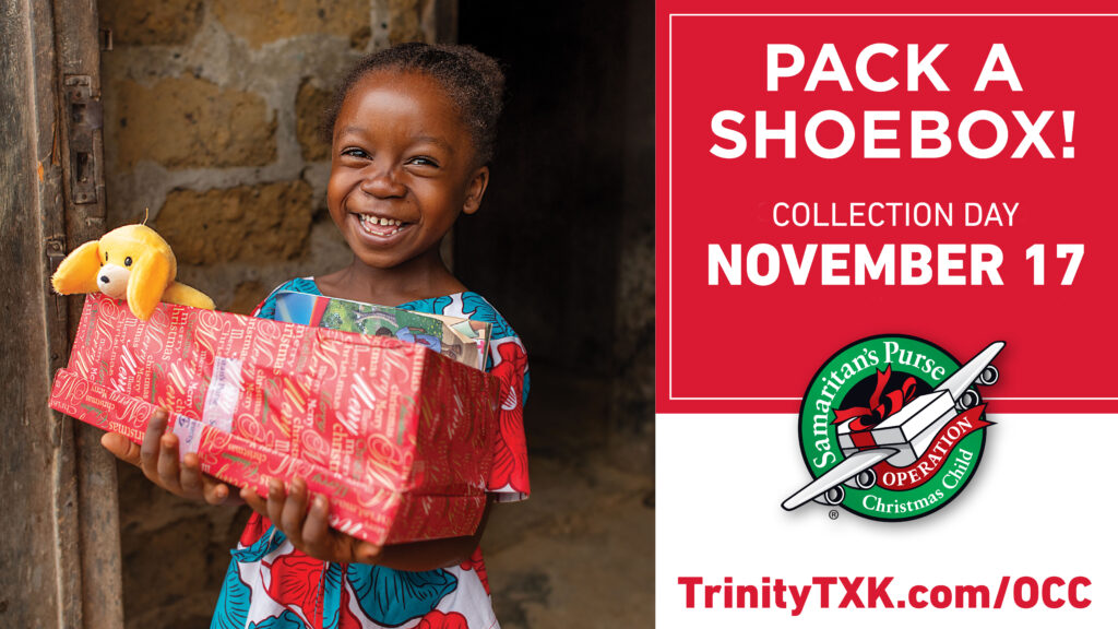 A girl smiles while holding a wrapped shoebox filled with toys received from Operation Christmas Child.