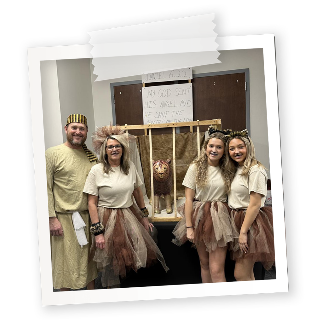 A church trunk-or-treat booth for Daniel 6:22 featuring Daniel and the Lions Den. Man dressed up as Daniel and three ladies dressed up as lions.