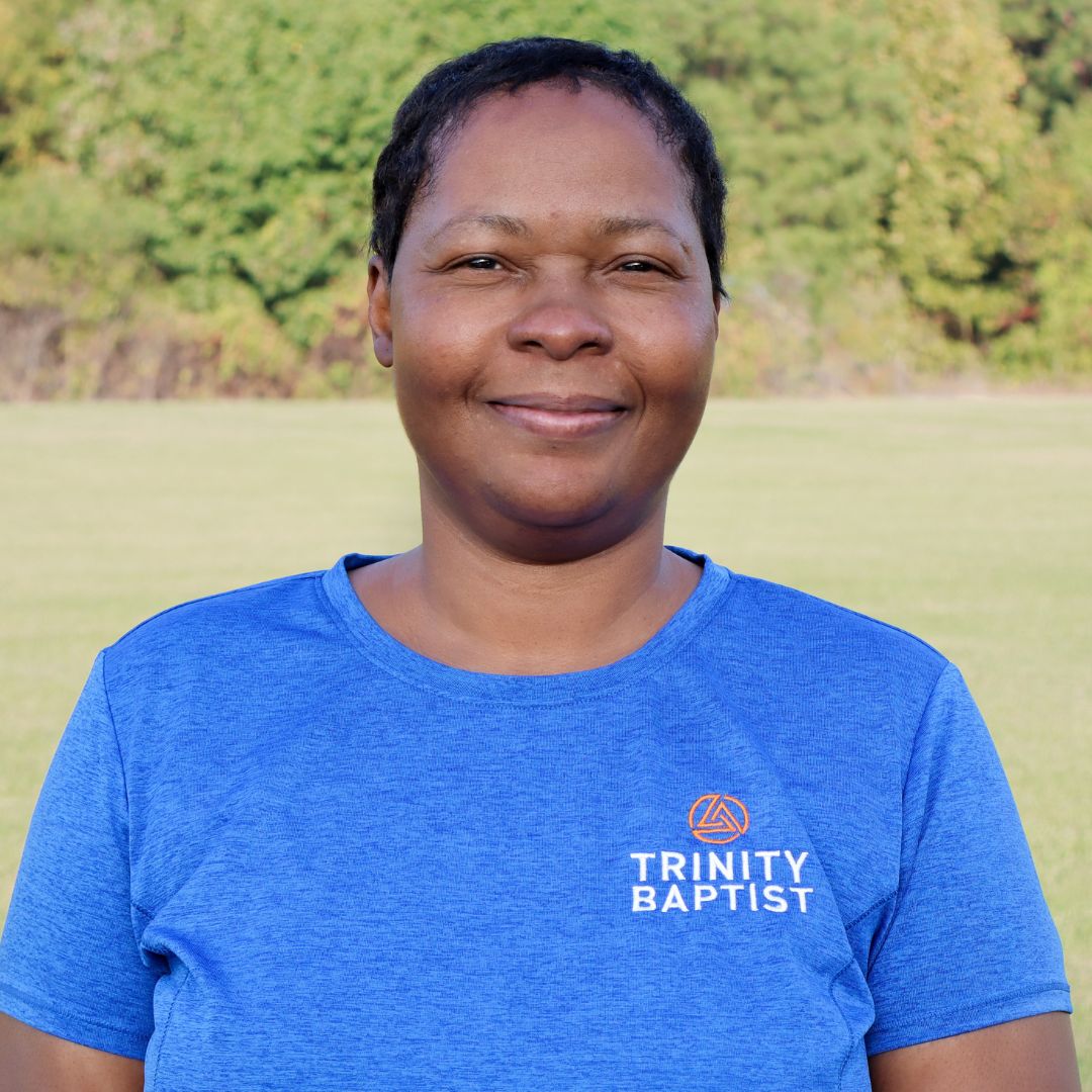 Custodian Bonne Roberts standing in front of trees