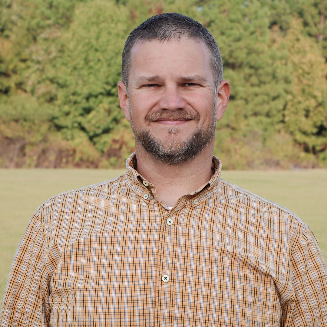 Director of Facilities Nick Hyman standing in front of trees